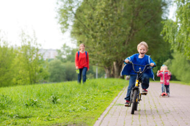 a kid riding a bike on the sidewalk